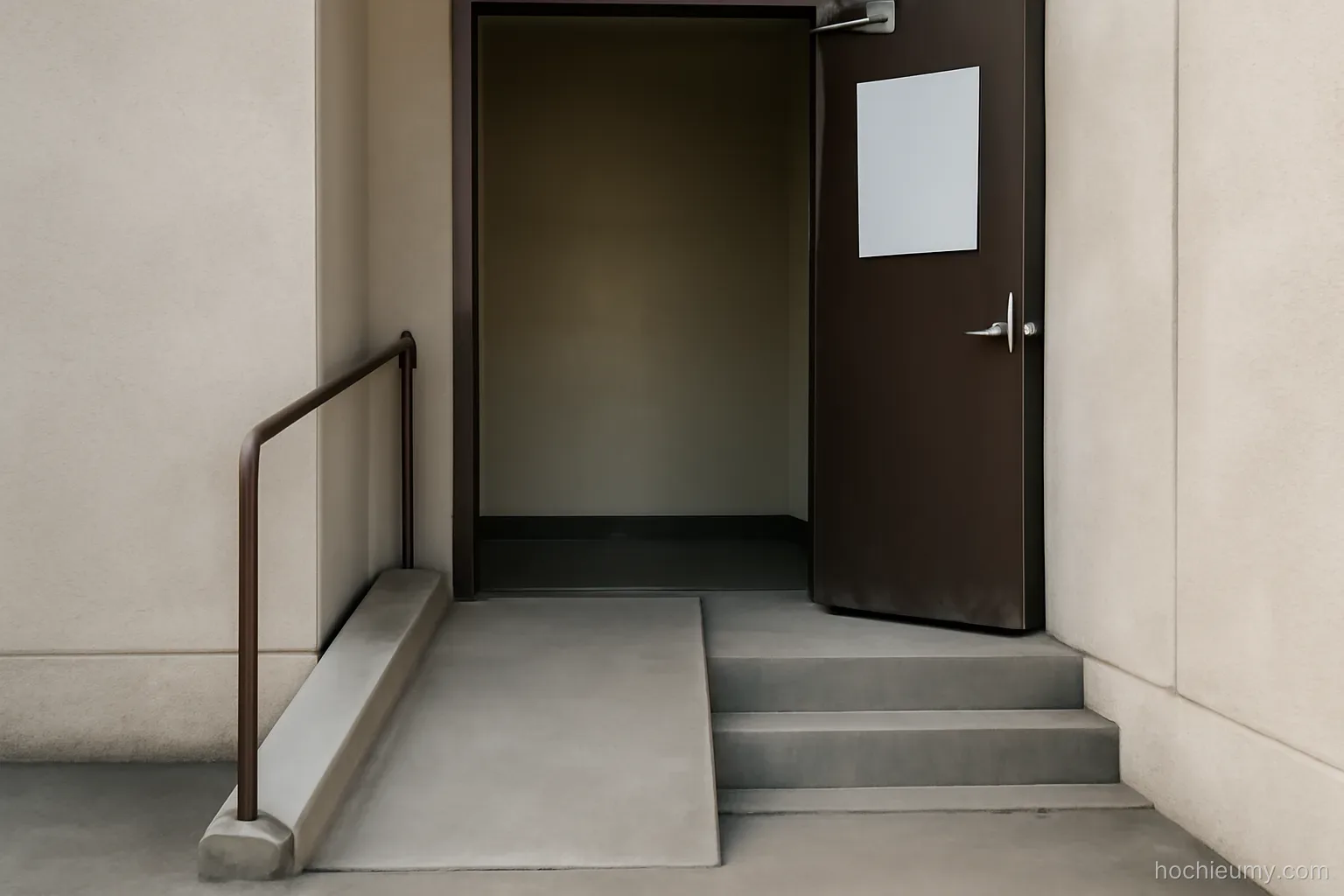 an open doorway with a ramp leading up to it beside a set of three shallow concrete steps