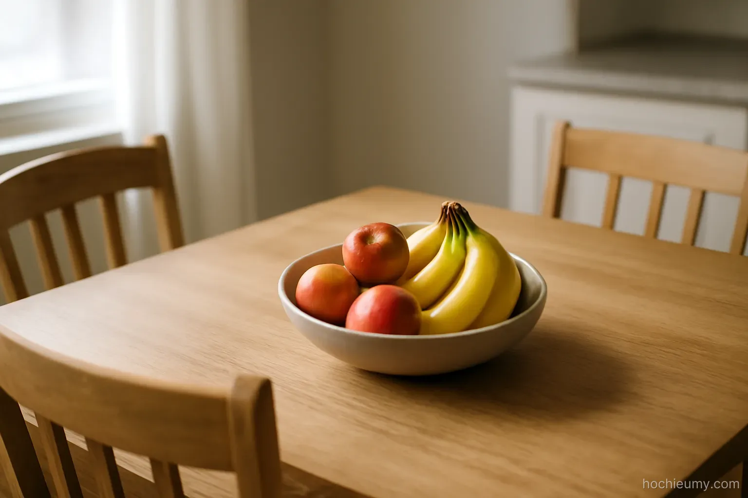 the same kitchen table seen from the same angle with two chairs and a bowl of fruit on it